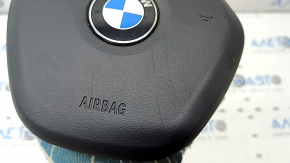 The steering wheel airbag for the driver's side of a BMW 3 G20 19-24 is black, with a rusty squib and scratches.