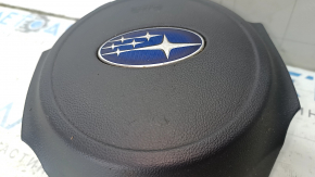 The driver's side airbag in the steering wheel of a 1920s Subaru Legacy, pre-restoration, has scratches and a rusty squib.