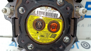 The driver's side airbag in the steering wheel of a 1920s Subaru Legacy, pre-restoration, has scratches and a rusty squib.