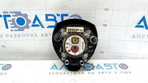 The driver's side airbag in the steering wheel of a Nissan Rogue 17-20 is black and scratched.