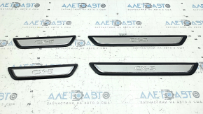 A set of black door sill plates for the Mazda CX-5 17-25 with a chrome insert and backlight, scratches
