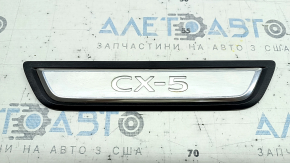 A set of black door sill plates for the Mazda CX-5 17-25 with a chrome insert and backlight, scratches