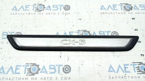 A set of black door sill plates for the Mazda CX-5 17-25 with a chrome insert and backlight, scratches
