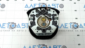 The Jeep Cherokee KL 19-23 driver's steering wheel airbag is black and has a rusty squib.
