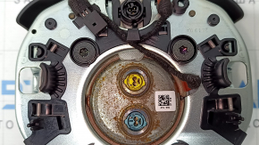 The Jeep Cherokee KL 19-23 driver's steering wheel airbag is black and has a rusty squib.