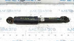 The rear left shock absorber of a Hyundai Santa FE Sport 17-18 restyling FWD is dented.