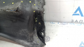 The front bumper guard on the left Mazda 3 19-24 4d is torn, worn, has cracks and tears.