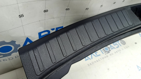 The trunk opening trim for a Toyota Prius 50 16-22 is black, worn, and has scratches.