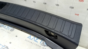 The trunk opening trim for a Toyota Prius 50 16-22 is black, worn, and has scratches.