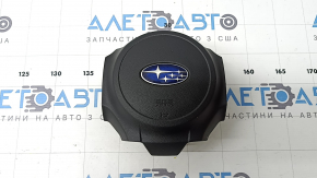 The driver's side airbag in the steering wheel of a 1995 Subaru Outback is black and has a rusty squib.