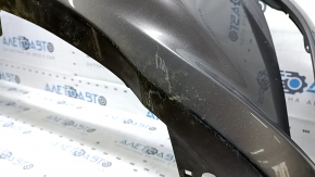 The front bumper of a Toyota Camry V55 2015-2017 (USA) is cracked, dented, and has scratches.