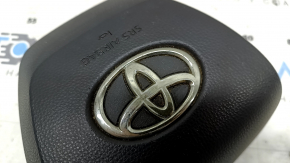 The driver's side airbag in the steering wheel of a Toyota Highlander 20-21 is black, the squib is rusty, the chrome on the emblem is peeling.