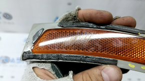 The front right reflector of the BMW 3 F30 16-18 has come unglued, is worn, and there are cracks in the glass.