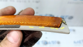 The front right reflector of the BMW 3 F30 16-18 has come unglued, is worn, and there are cracks in the glass.
