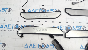 A set of door sills for the Nissan Ariya 23-25, black with chrome insert and backlighting.