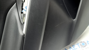 The door trim panel, rear left, Toyota Rav4 19-24, is black, the armrest is black leather, the insert is black plastic, the molding with the handle is gray, scratches are visible.