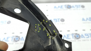 The left radiator grill bracket for Mazda CX-30 20-23 is dented and cracked.