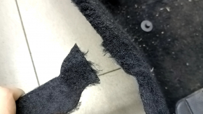 The floor covering of the VW Jetta 19-24 is black, torn, needs cleaning.