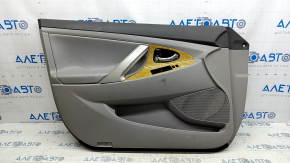 The front left door panel of a Toyota Camry v40 is gray, the armrest is gray leather, the insert is wood, with a handle, no controls, the plastic has turned white, needs cleaning, the leather has peel