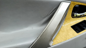 The front left door panel of a Toyota Camry v40 is gray, the armrest is gray leather, the insert is wood, with a handle, no controls, the plastic has turned white, needs cleaning, the leather has peel
