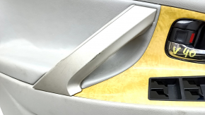 The front left door panel of a Toyota Camry v40 is gray, the armrest is gray leather, the insert is wood, with a handle, no controls, the plastic has turned white, needs cleaning, the leather has peel