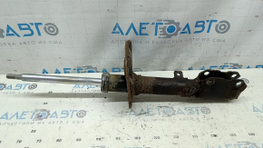 The rear left shock absorber of a Toyota Camry v40 XLE is rusty.