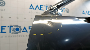 The front left door of a Mazda CX-9, 16-23, has a dent and a bump.