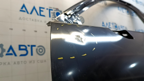 The front left door of a Mazda CX-9, 16-23, has a dent and a bump.