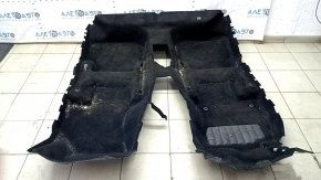 The floor covering of the VW Jetta 19-24 is black, torn, needs cleaning.