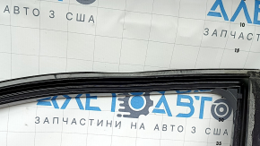 The front left door of a Nissan Rogue 21-24, black KH3, is bare, the frame is dented.