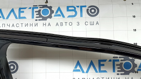 The front left door of a Nissan Rogue 21-24, black KH3, is bare, the frame is dented.