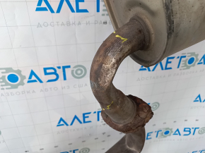 The exhaust pipe, the middle part of a Toyota Camry v40 3.5, is dented and rusty.