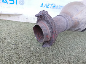 The exhaust pipe, the middle part of a Toyota Camry v40 3.5, is dented and rusty.