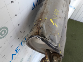 The exhaust pipe, the middle part of a Toyota Camry v40 3.5, is dented and rusty.