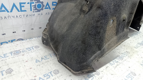 The rear left fender liner of a Toyota Sienna 21-24 is dented and torn.