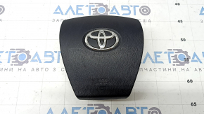 The driver's side airbag in the Toyota Prius V 12-17 is black, scratched, and has a rusty squib.