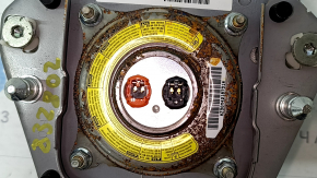 The driver's side airbag in the Toyota Prius V 12-17 is black, scratched, and has a rusty squib.