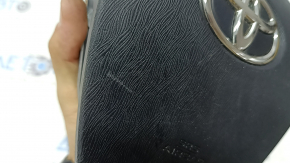 The driver's side airbag in the Toyota Prius V 12-17 is black, scratched, and has a rusty squib.