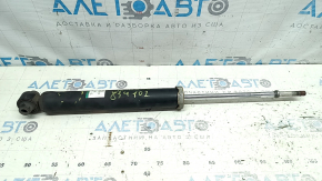 The rear left shock absorber of a Toyota Prius V 12-14 is dented.
