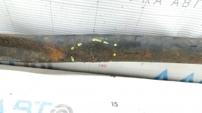 The rear beam strut of a Toyota Prius V 12-17 is dented and rusty.