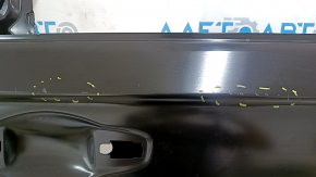 The rear right door of a Honda Accord is bare and has dents.