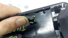 The lower central trim panel of the Hyundai Tucson 22-24 is black, worn, scratched, and the fastener is broken.