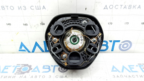 The driver's side airbag in the steering wheel of a VW Tiguan 18-21 is black and scratched.