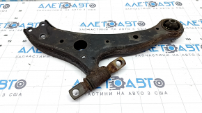 The lower front left control arm of a Toyota Camry V50 12-14 USA is rusty and has a cracked silent block.