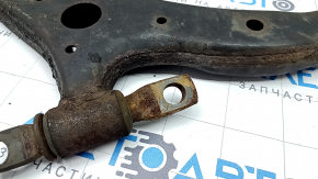 The lower front left control arm of a Toyota Camry V50 12-14 USA is rusty and has a cracked silent block.