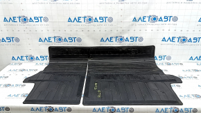 The trunk mat on the back of the seats of a Toyota Rav4 19-25 is black rubber and has a tear.