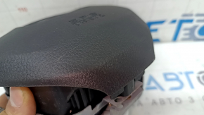The Honda Insight 19-22 driver's steering wheel airbag is black and scratched.