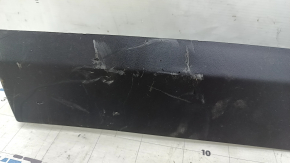The lower rear left door trim of a Jeep Compass 17-24 is worn and scratched.
