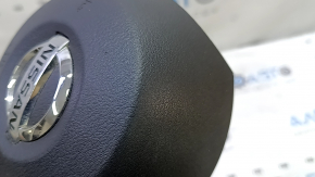 The driver's side airbag in the steering wheel of a Nissan Rogue Sport 20-22 is black and scratched.