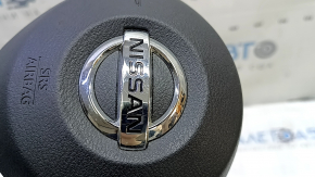 The driver's side airbag in the steering wheel of a Nissan Rogue Sport 20-22 is black and scratched.